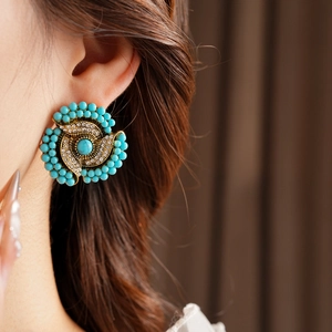 Detail of vintage flower stud earring with turquoise beads and crystals on model