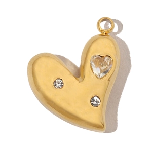 Close-up of golden heart pendant with three sparkling zircons and polished finish