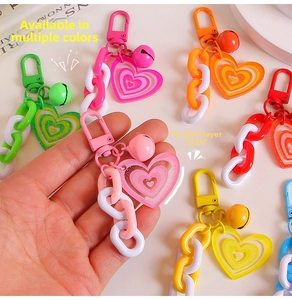 Close-up of double-layer heart keychains with colorful chains and small metal bells