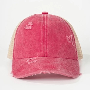 Detailed close-up of distressed ponytail trucker hat with mesh back and vintage pink fabric
