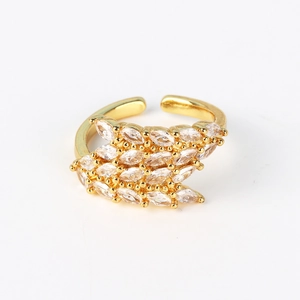 Macro detail of gold-plated open ring featuring a row of marquise-cut white zircons