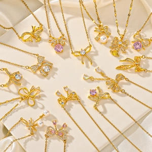 Golden bow pendant necklace with colorful cubic zirconia and pearls on silk