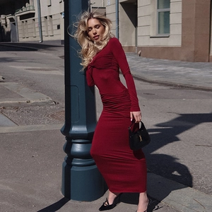 Détail de la robe longue rouge moulante avec tissu froncé portée par un mannequin de rue