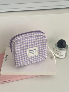 Vista macro de la mini bolsa acolchada a cuadros morados y blancos con etiqueta