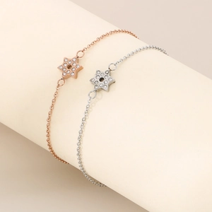 Détail de bracelets étoiles en or rose et argent avec pavé de zircones sur support doux
