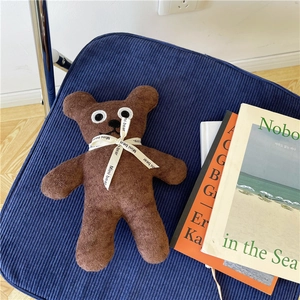 Brown teddy bear plush toy made of bouclé fabric with a white Mini Bear ribbon