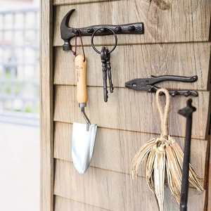 Vintage cast iron tool-shaped wall hooks featuring hammer and pliers for home decor