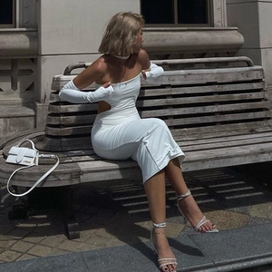 Outdoor street style shot of a white cutout A-line dress with matching neckpiece and sleeves