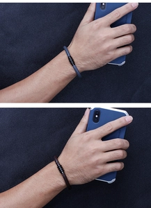 Close-up of men's braided microfiber leather bracelets in blue and brown with steel rings