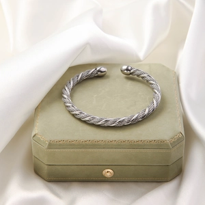 Detailed view of silver braided twisted cable cuff bracelet with polished end beads