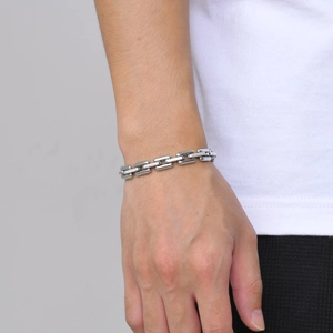Close-up of a silver stainless steel link bracelet on a male wrist with hip hop style