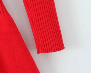 Detailed macro shot of red ribbed knit texture and sleeve cuff of the slim dress