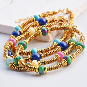 Detailed close-up of bohemian colorful tourmaline beads and golden stainless steel bracelets