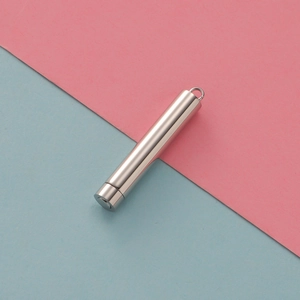 Polished silver stainless steel cylindrical pendant container on a bicolor pastel background