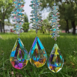 Dettaglio di tre acchiappasole in cristallo con pendenti sfaccettati e finitura arcobaleno