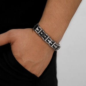 Men's stainless steel and black silicone cross bracelet worn on wrist for casual style