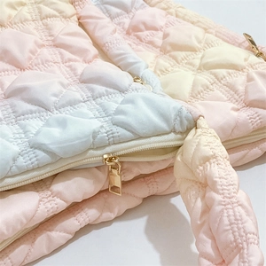 Detail of pink gradient cloud bag with quilted fabric and gold metal zipper closure