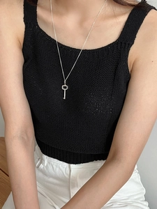 Minimalist S925 sterling silver key pendant necklace worn on a model with black knitwear
