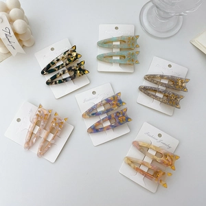 Cat-shaped acetate hair clip set with marble patterns on a white display card