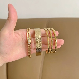 Set di bracciali a catena dorata e rigidi geometrici testurizzati da donna