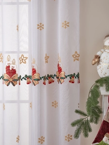 Close-up of white Christmas sheer curtain with red bell and snowflake embroidery