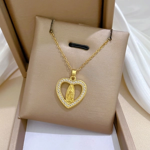 Macro detail of gold heart pendant with crystal border and relief in a velvet gift box