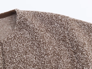 Macro detail of the brown and beige tweed knit jacket's textured round neckline