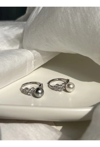 Close-up of S925 silver ring with gray and white pearls set on a ceramic dish