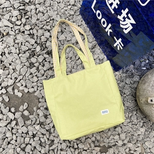 Primer plano de bolso de lona verde claro con forro de cuadros amarillos y blancos modernos