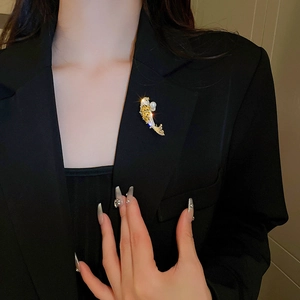 Golden koi fish brooch with zircon and pearl on a black suit jacket for women