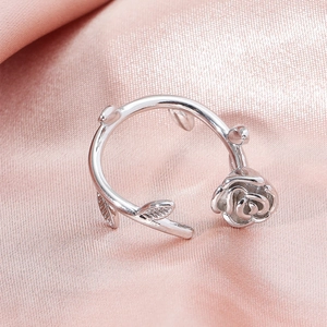 Elegant silver 3D rose flower ring with detailed leaf texture on pink satin background