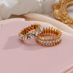 Close-up of gold stacking rings featuring emerald and marquise-cut sparkling zircons