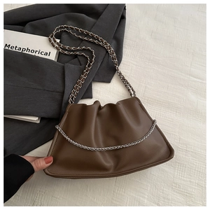 Close-up of brown pleated cloud bag with soft synthetic leather and silver chain