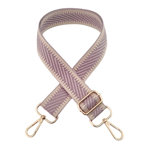 Detail of purple and beige woven bag strap with golden metal hooks and adjustable buckle