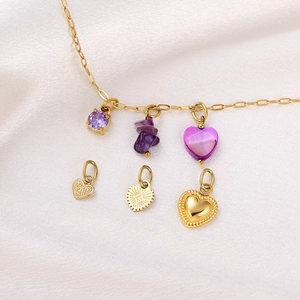 Detail of gold necklace with purple gemstones and diverse golden heart-shaped pendants