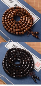 Detailed close-up of 8mm green sandalwood prayer beads in brown and black on a bamboo mat