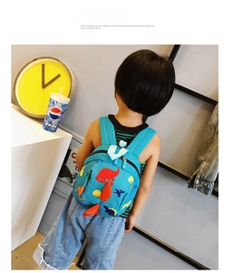 Blue kids backpack with 3D orange dinosaur tail and spikes for toddlers outdoors
