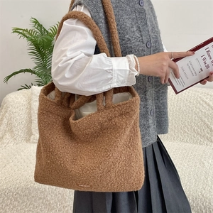 Detailed view of brown teddy fleece tote bag with soft plush texture and woven logo tag