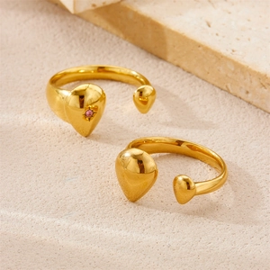 Detailed view of two 18K gold plated vintage rings with a pink gemstone on stone surface