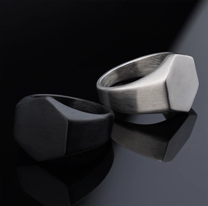 Macro view of matte black and brushed silver hexagonal stainless steel rings with reflections