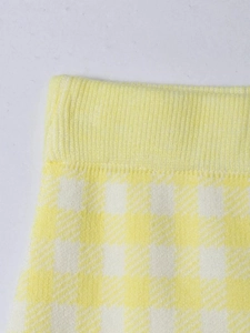 Detailed macro view of yellow and white plaid knitted fabric showing elastic waist texture