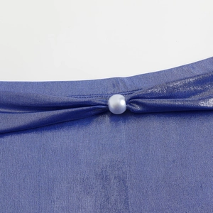 Detail shot of shimmering blue bikini fabric with elegant pearl bead accent