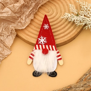 Détail du porte-couverts gnome de Noël rouge et blanc sur un fond en bois