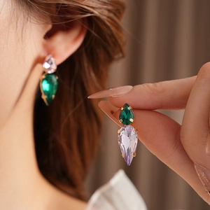 Detailed close-up of zircon teardrop pendant earrings with multi-faceted crystal inlay