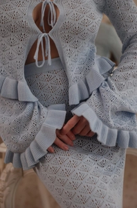 Detailed view of light blue hollow-out knit two-piece set featuring lace-up ruffle top