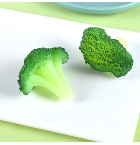 Macro shot of realistic resin broccoli models showing fine granular texture on a white plate