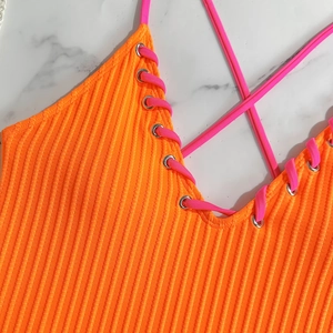 Detail of orange ribbed swimwear with pink lace-up ties and silver metal eyelets