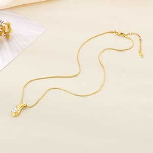Macro shot of 18K gold plated teardrop pendant with zircon stone on a sleek snake chain
