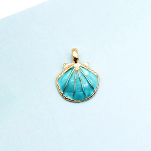 Makroaufnahme eines vergoldeten Muschel-Anhängers mit seeblauem Emaille für DIY-Schmuck