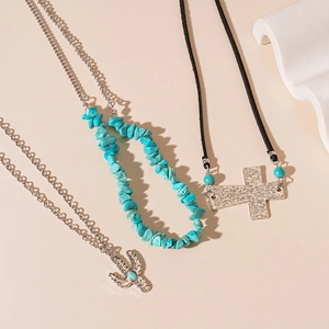 Detail of 3-piece boho necklace set featuring a turquoise cactus and cross pendant